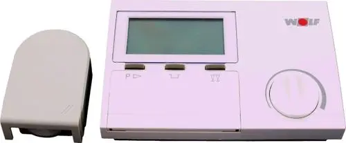 Digitaler Temperaturregler von Wolf mit Display und Steuerknopf. Zubehörteil auf der linken Seite. Gerät in neutraler Farbgebung, geeignet für Steuerungsanwendungen.